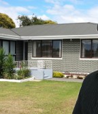 Rene McLean beside a typical Manurewa home that he regularly values.