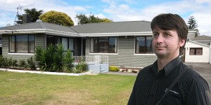 Rene McLean beside a typical Manurewa home that he regularly values.